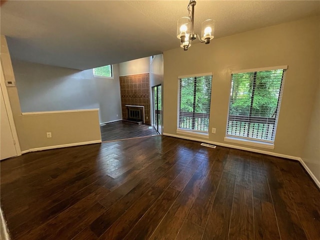 2449 Terrace Trl, Decatur, GA 30035 - unfurnished living room featuring baseboards, dark wood-style floors, a chandelier, and a tiled fireplace