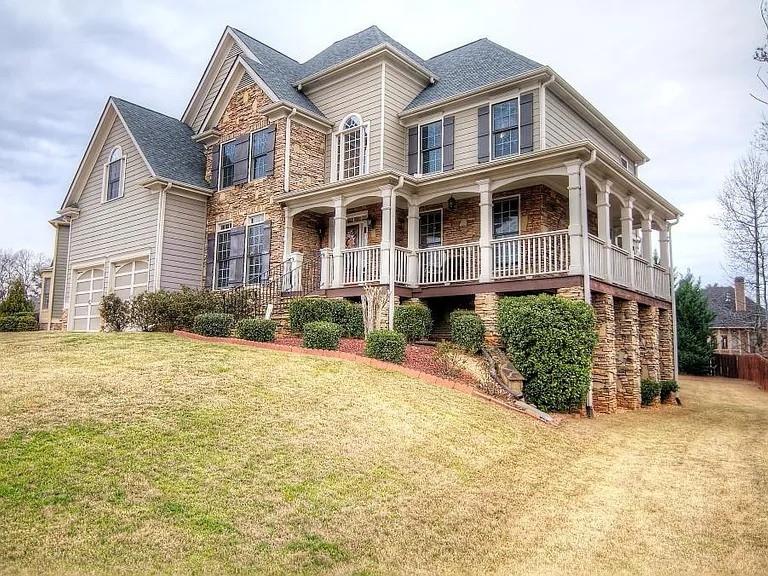 5610 Hollowbrooke Ln, Acworth, GA 30101 - view of front of house featuring a porch, a garage, stone siding, and a front lawn