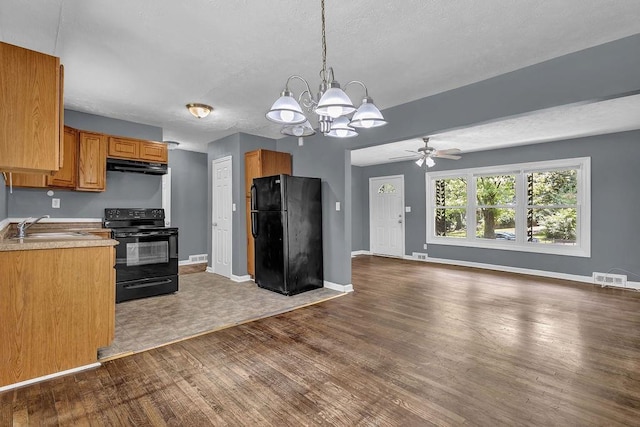 1911 Rosewood Rd, Decatur, GA 30032 - kitchen with black appliances, a sink, under cabinet range hood, a chandelier, and open floor plan