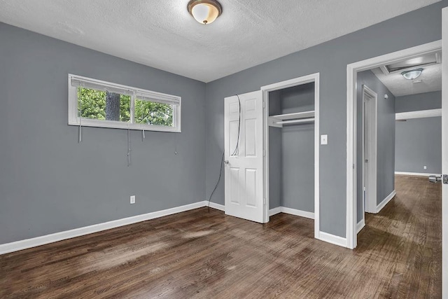 1911 Rosewood Rd, Decatur, GA 30032 - unfurnished bedroom with a textured ceiling, dark wood-type flooring, baseboards, and a closet