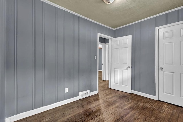 1911 Rosewood Rd, Decatur, GA 30032 - unfurnished bedroom featuring dark wood-type flooring, a textured ceiling, baseboards, and crown molding