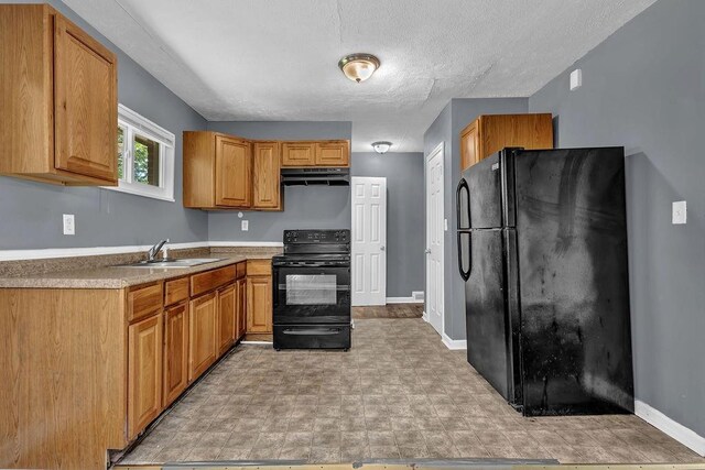1911 Rosewood Rd, Decatur, GA 30032 - kitchen featuring black appliances, a sink, under cabinet range hood, baseboards, and light countertops
