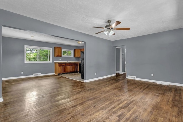 1911 Rosewood Rd, Decatur, GA 30032 - unfurnished living room featuring dark wood finished floors, a ceiling fan, baseboards, and a textured ceiling