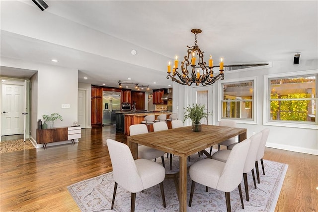 dining room featuring dark hardwood / wood-style flooring, sink, and a notable chandelier