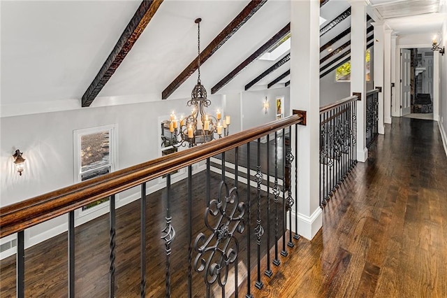 stairway with an inviting chandelier, hardwood / wood-style floors, and lofted ceiling with beams