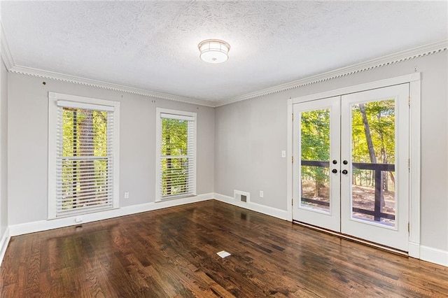 empty room with dark hardwood / wood-style floors, ornamental molding, french doors, and a textured ceiling