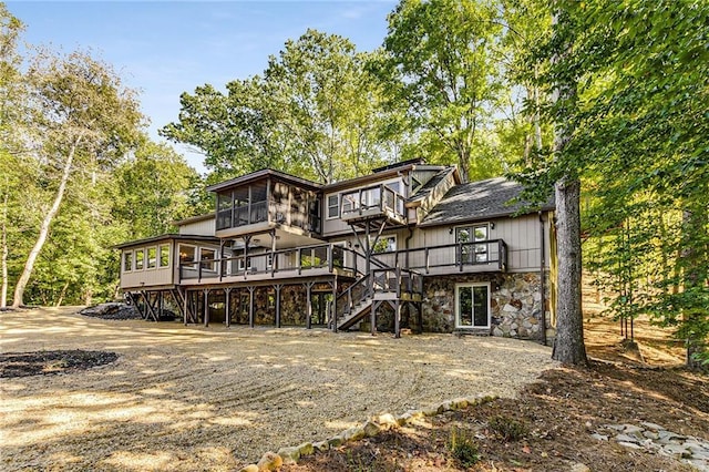 back of property featuring a wooden deck and a sunroom