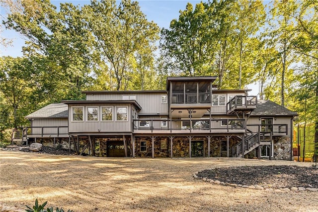 rear view of property featuring a wooden deck and a sunroom