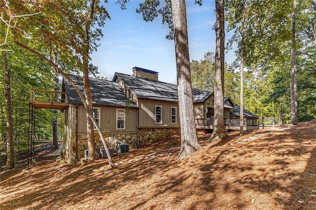 rear view of property with a deck and central air condition unit