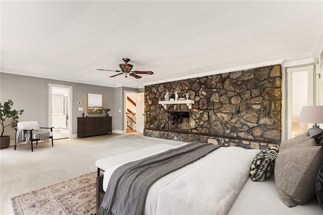 bedroom with crown molding, ceiling fan, a fireplace, and carpet