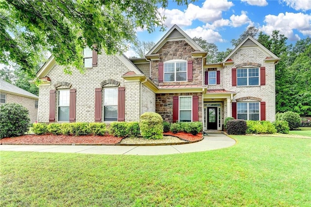 view of front of house featuring brick siding, stone siding, and a front lawn