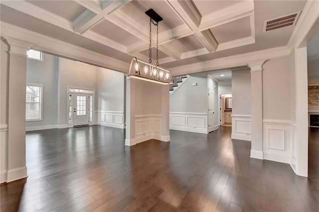 interior space with visible vents, dark wood-type flooring, beam ceiling, and a decorative wall