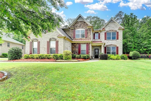 craftsman-style home with stone siding, brick siding, and a front yard