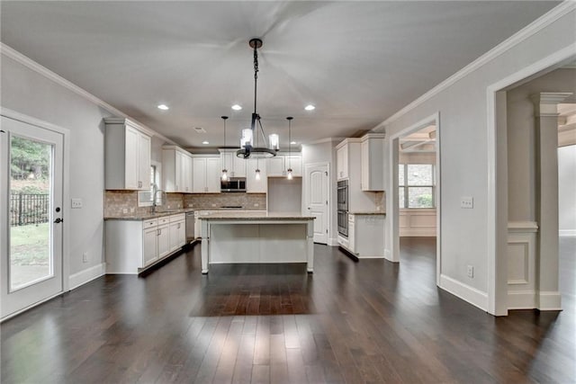 kitchen with backsplash, stainless steel appliances, a chandelier, and a wealth of natural light