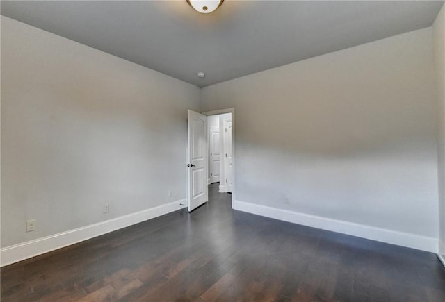 empty room with baseboards and dark wood-style floors