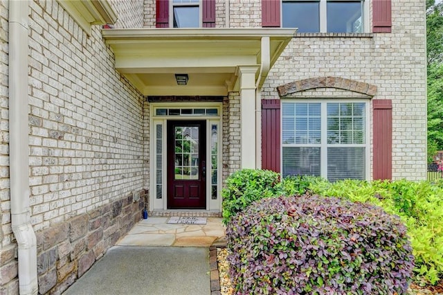 doorway to property featuring brick siding