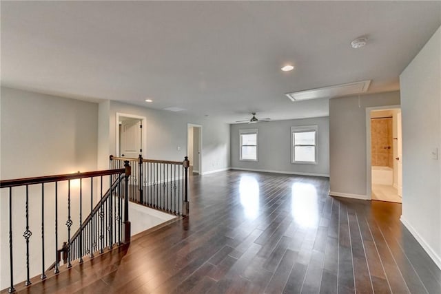 unfurnished room with recessed lighting, baseboards, attic access, and dark wood-style floors