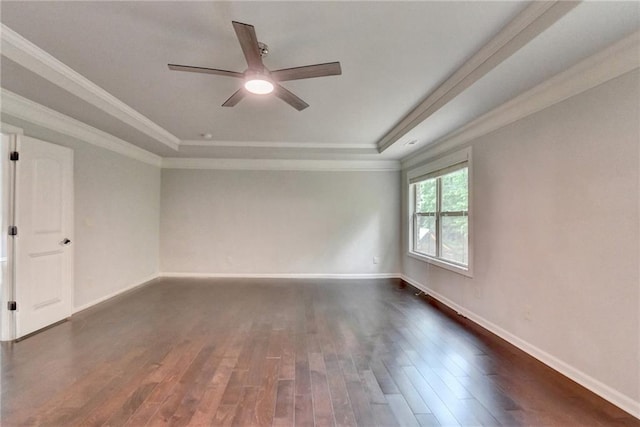 empty room featuring crown molding, baseboards, ceiling fan, a tray ceiling, and dark wood finished floors
