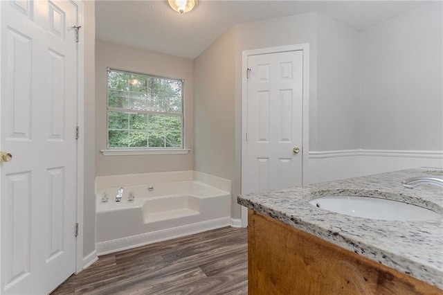260 Pleasant Grove Cir, Mcdonough, GA 30252 - bathroom with double vanity, wood finished floors, a garden tub, and baseboards