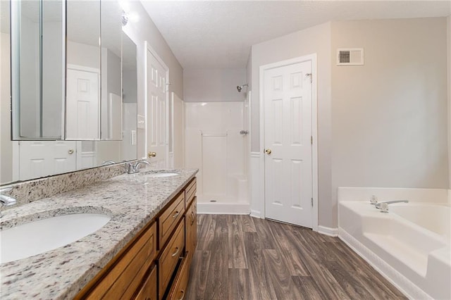 260 Pleasant Grove Cir, Mcdonough, GA 30252 - bathroom with wood finished floors, a garden tub, a stall shower, double vanity, and baseboards