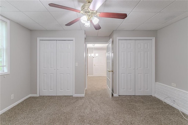 260 Pleasant Grove Cir, Mcdonough, GA 30252 - unfurnished bedroom with carpet, two closets, a chandelier, a paneled ceiling, and a ceiling fan