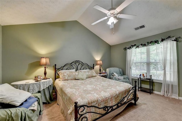 carpeted bedroom with a textured ceiling, vaulted ceiling, and ceiling fan