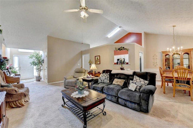 carpeted living room featuring high vaulted ceiling and ceiling fan with notable chandelier