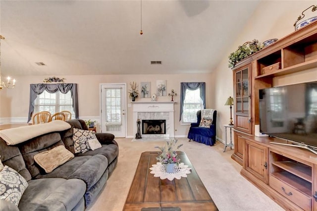 carpeted living room featuring vaulted ceiling and a chandelier