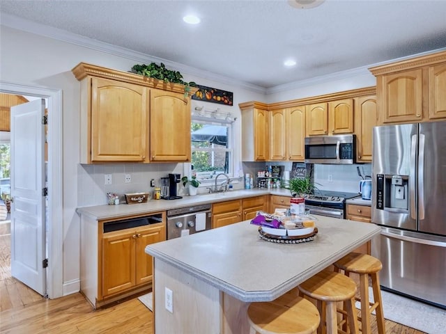 kitchen featuring a breakfast bar, a center island, backsplash, light wood-type flooring, and stainless steel appliances