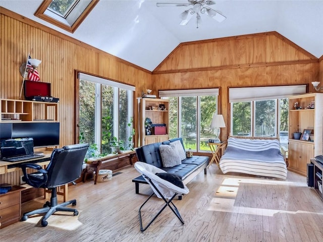 sunroom featuring vaulted ceiling with skylight, ceiling fan, and plenty of natural light