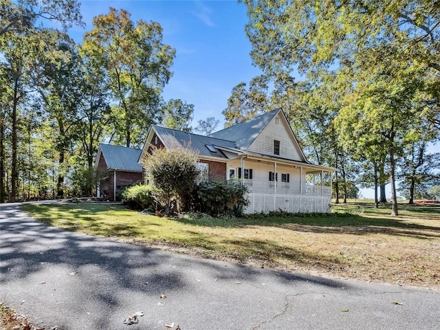 view of home's exterior with a yard and covered porch