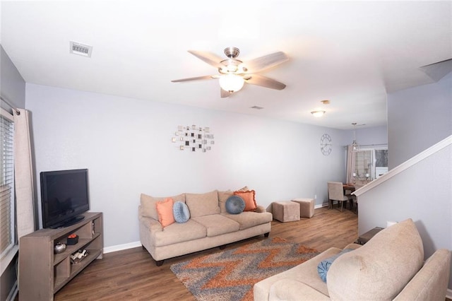 living area with visible vents, stairway, ceiling fan, and wood finished floors