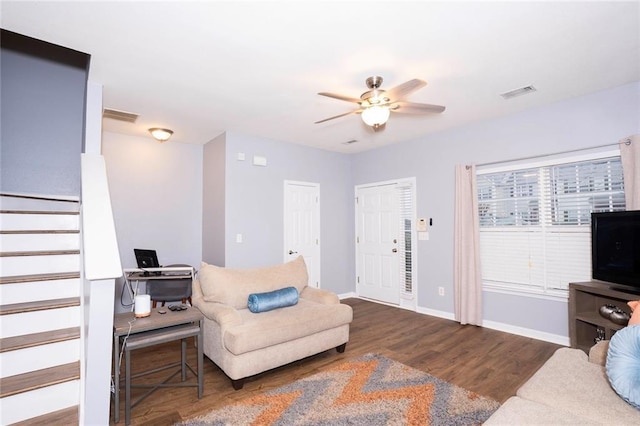 living area featuring ceiling fan, visible vents, baseboards, and wood finished floors