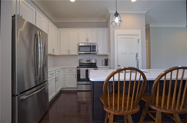 kitchen featuring backsplash, crown molding, light countertops, stainless steel appliances, and white cabinetry