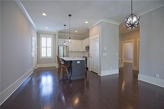 kitchen with a kitchen bar, crown molding, light countertops, stainless steel appliances, and dark wood-type flooring