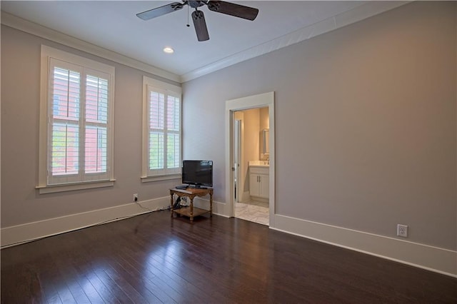 spare room featuring crown molding, a ceiling fan, dark wood finished floors, and plenty of natural light