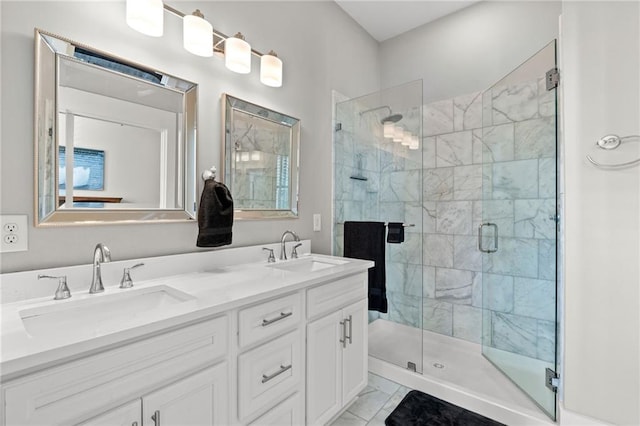 bathroom with double vanity, a shower stall, and a sink