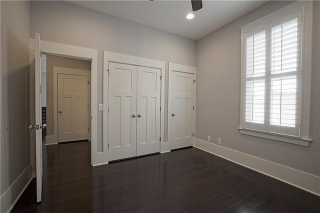 unfurnished bedroom featuring recessed lighting, baseboards, dark wood-style floors, and a closet