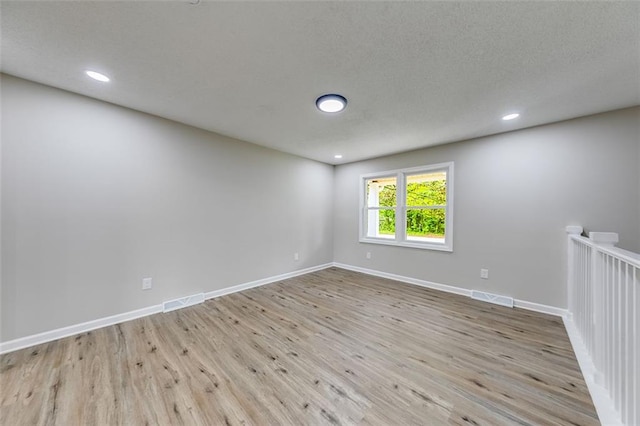 spare room with baseboards, visible vents, wood finished floors, and recessed lighting
