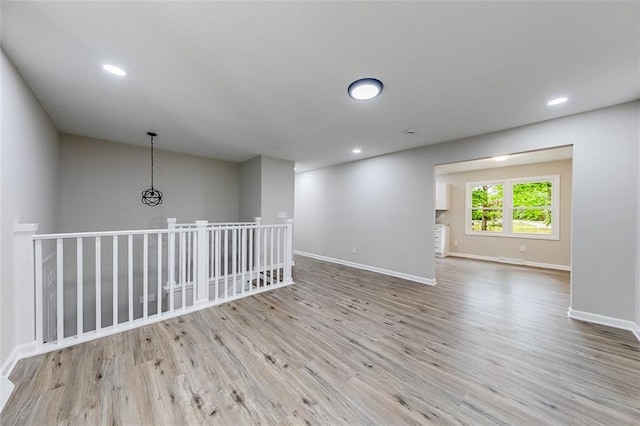 spare room featuring wood finished floors, recessed lighting, and baseboards