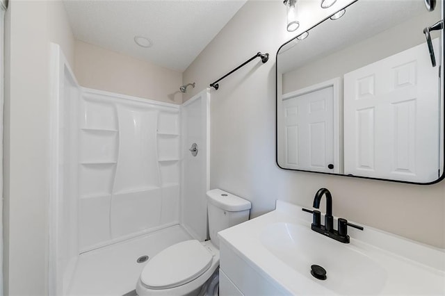 bathroom with toilet, walk in shower, and vanity