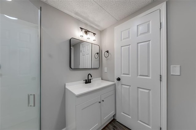 bathroom featuring a stall shower, wood finished floors, and vanity