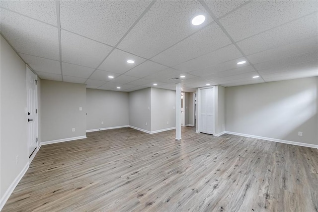finished basement with wood finished floors, recessed lighting, a drop ceiling, and baseboards