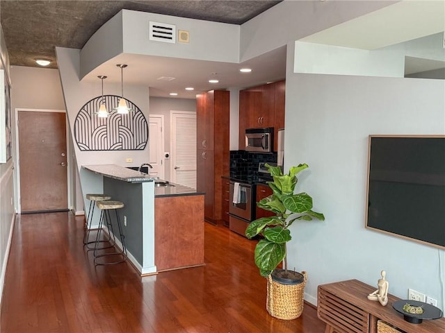 860 Peachtree St NE Unit 1411, Atlanta, GA 30308 - kitchen with appliances with stainless steel finishes, a breakfast bar area, dark wood-style flooring, dark countertops, and recessed lighting