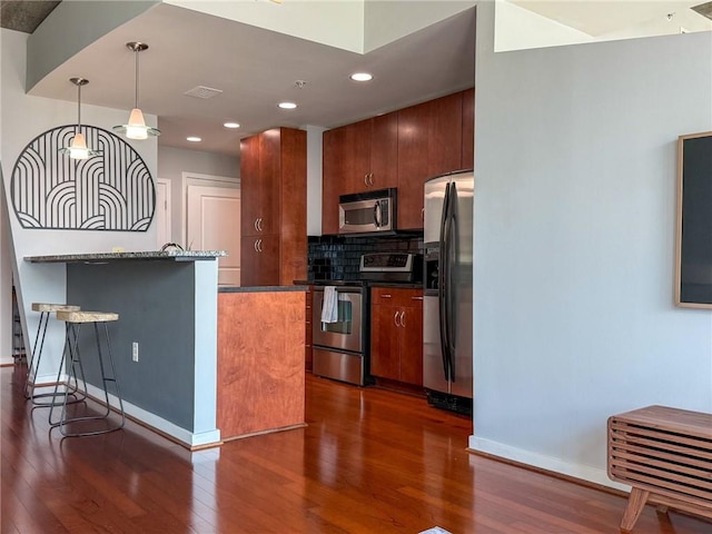 860 Peachtree St NE Unit 1411, Atlanta, GA 30308 - kitchen with appliances with stainless steel finishes, dark wood-style flooring, tasteful backsplash, baseboards, and a kitchen bar
