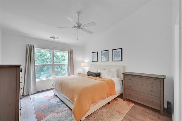 bedroom featuring light wood-type flooring, lofted ceiling, and ceiling fan