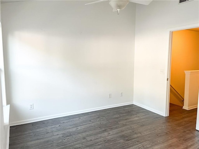 spare room with dark hardwood / wood-style flooring and ceiling fan