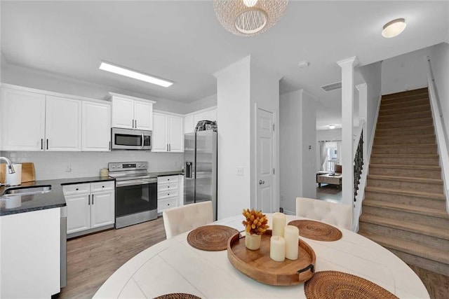 kitchen featuring light wood-type flooring, white cabinets, sink, and stainless steel appliances