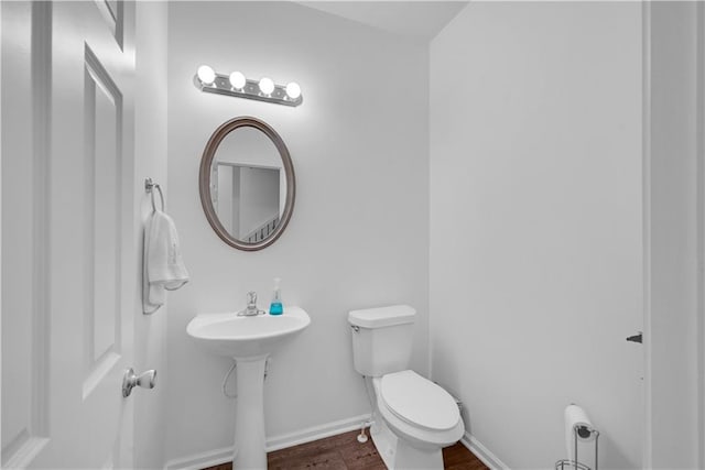 bathroom with hardwood / wood-style floors, sink, and toilet