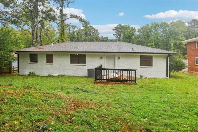 rear view of house featuring a wooden deck, cooling unit, a lawn, and brick siding